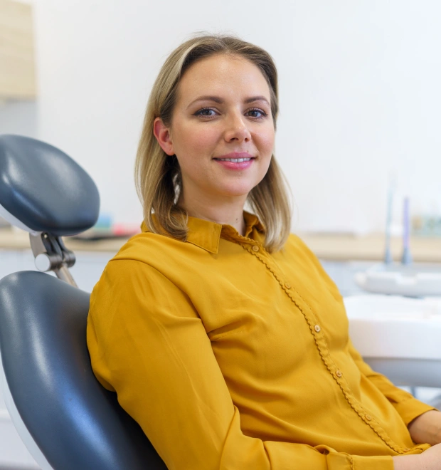 Woman in yellow top sitting in a dental chair