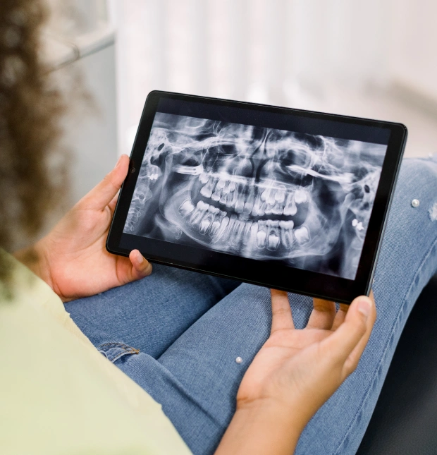 Dental professional reviewing digital x rays on a screen