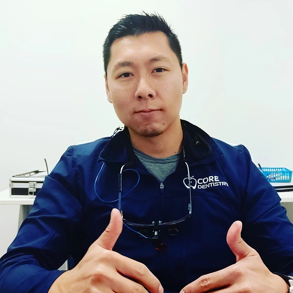 Dr. Daniel Kou wearing scrubs in the dental office