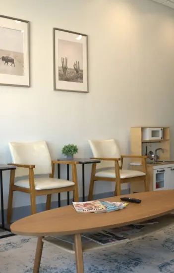 Modern dental office waiting room with comfortable wooden chairs and calming decor.
