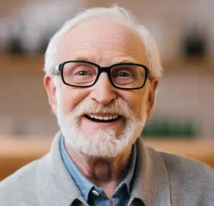 Smiling senior man with glasses representing a trusted dentist in Frisco, TX.